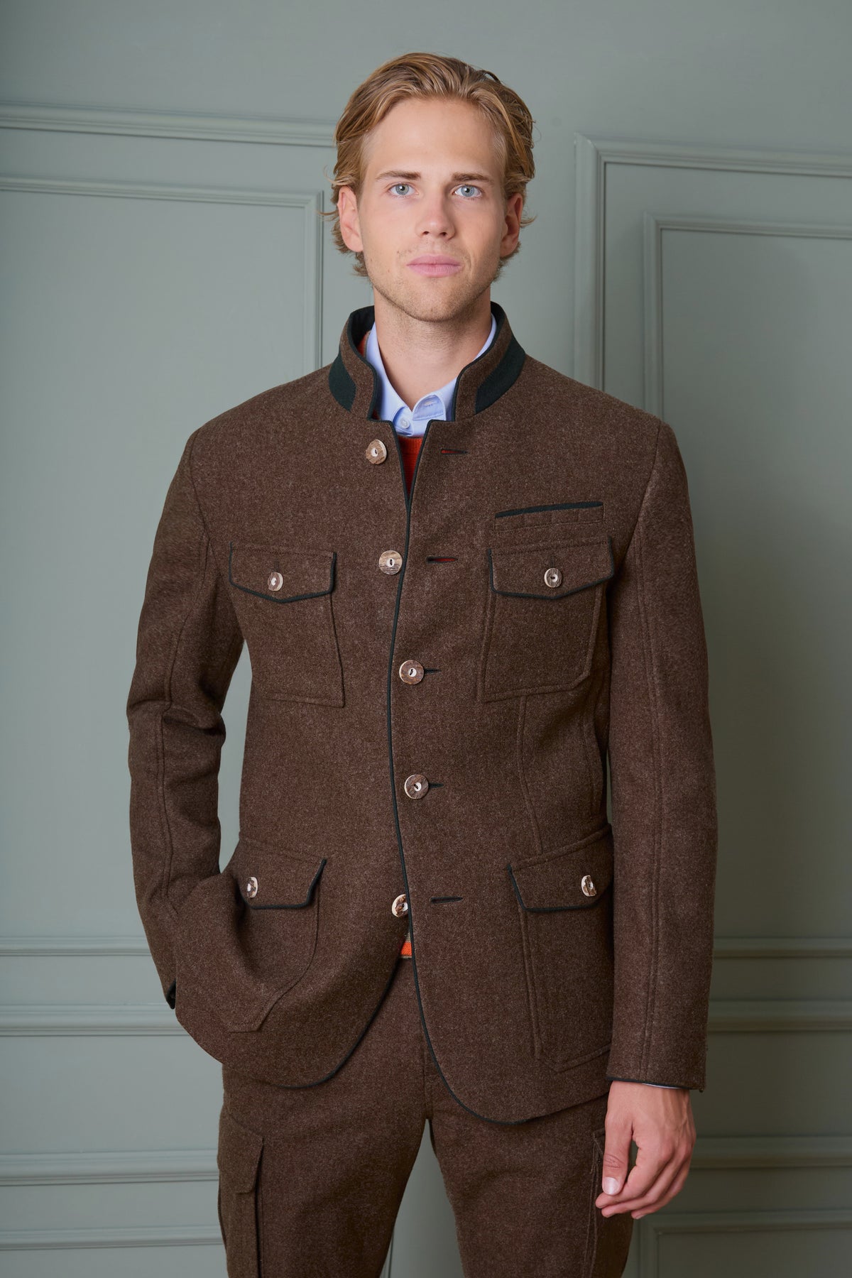 Model in brauner Lodenjacke vor grünem Hintergrund