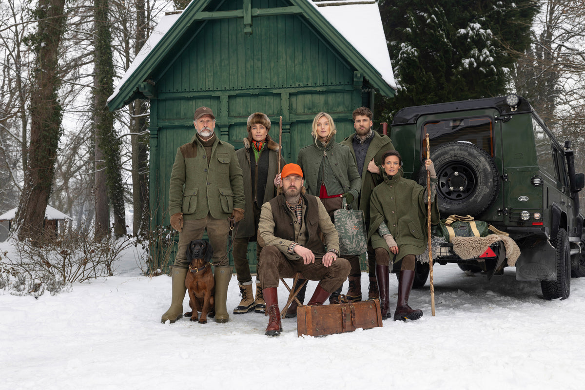 Habsburg Models posieren in neuer Herbst-/Winterkollektion in Winterlandschaft vor einer grünen Holzhütte.