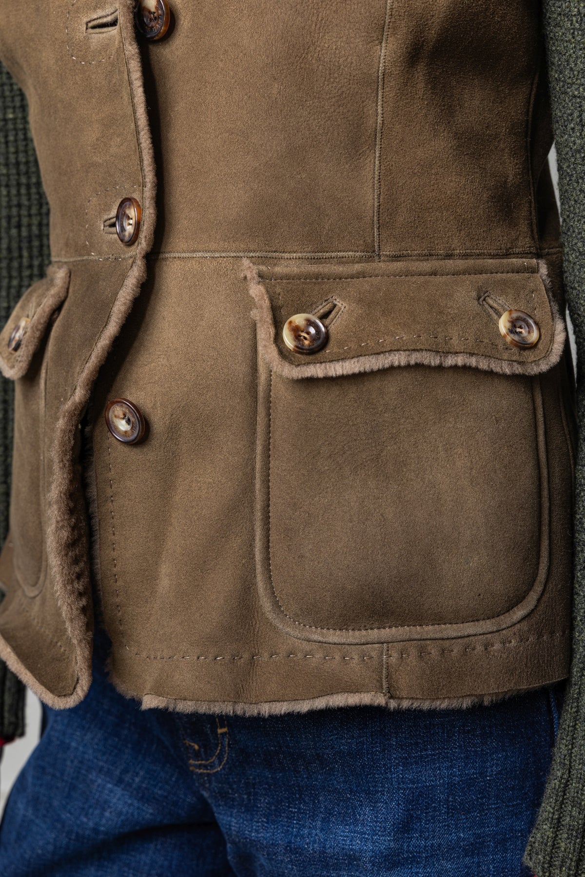 Detailaufnahme der Lammfelljacke Hollenburg in Oliv mit Strickärmeln für Damen